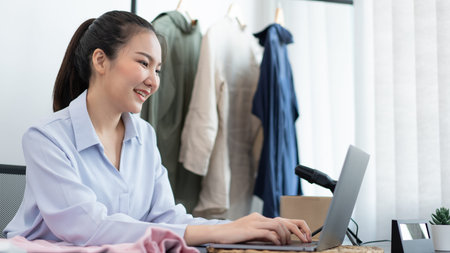 Live shopping concept a female dealer answering messages of customers explaining information and promotions of the goods.の写真素材