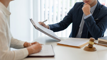 law concept The attorney holding the paper and having a law inspection about the contract of the company that the offer with his helper.の写真素材