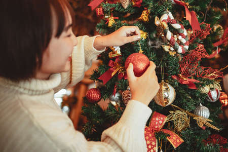 winter holidays concept, Happy woman Decorating Christmas tree for New Year celebrationの写真素材
