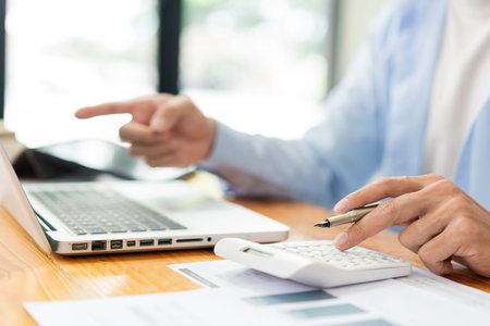 Business analyst concept the accountant using a calculator to estimate the amount of profits.の写真素材