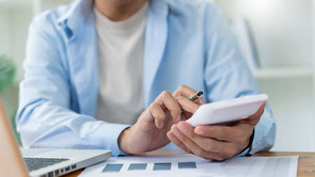 Business analyst concept the accountant looking at the information on the computer screen while calculating the numbers.の写真素材