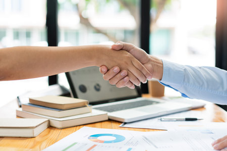 Business negotiation concept the estate representatives shaking hand each other to agree with the...