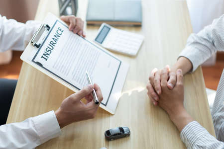 Insurance concept the auto dealer emphasizing on the agreement of the contract for his client.の写真素材