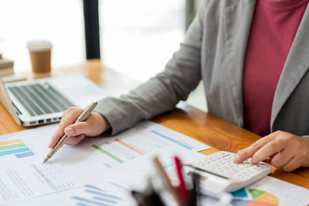 Business analyst concept the data analyst calculating the diagrams about the sale on the paperwork.の写真素材