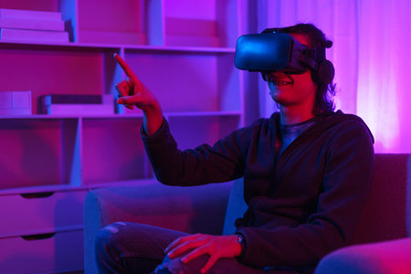 Metaverse technology concept, Man wear VR goggles and pointing to touch experience in virtual world.