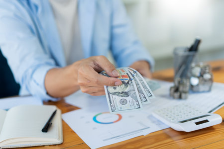 Saving concept the male money collector arranging his cash and coins on the desk.の写真素材