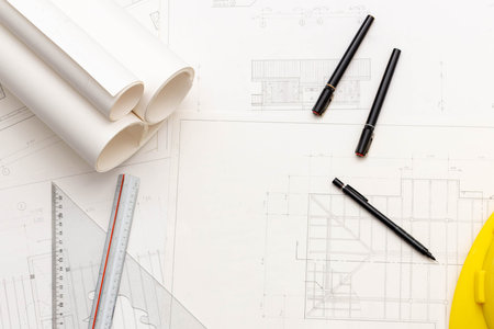 Mockup of architectural concept, Drawing tools and engineer drawing on blueprint with safety helmet.の写真素材