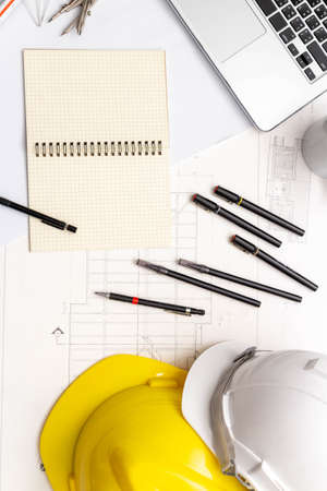 Mockup of architectural concept, Drawing tool and coffee on drawing of blueprint with safety helmet.の写真素材