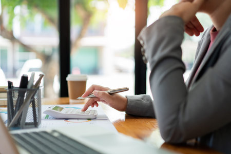 Business analyst concept the accountant using a calculator to figure out the number of the expense.