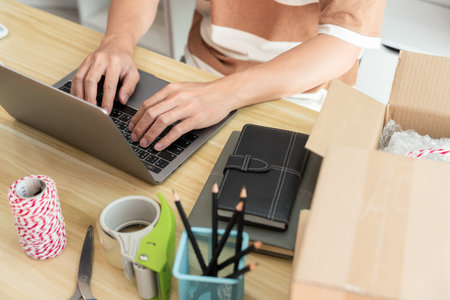 Online shopping concept an online seller typing on his laptop to fill the customer data.