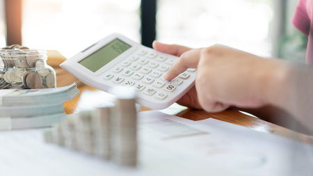 Saving concept the woman in a red top calculating monthly expense and income by using the...