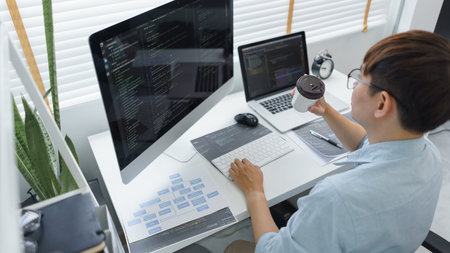 Software development concept, Male programmer checking website programming and drinking coffee.