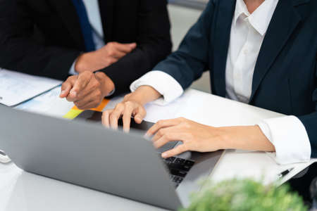 Business partnership concept, Businesswoman is discussing with senior while typing data on laptop.の写真素材