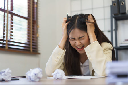 Secretary concept, Female secretary screaming and put hands on head while stressed with mistake job.の写真素材