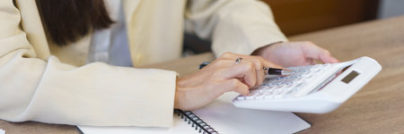 Work of secretary concept, Female secretary using calculator to calculate expenses of business.の写真素材