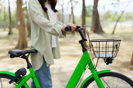 Women pushing bicycle and walking with having fun to resting after cycling to exercise in the park.