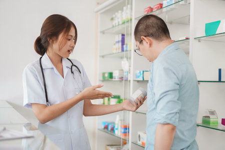 Medicine and health concept, Female pharmacist hold pill bottle to explaining medication for client.の写真素材