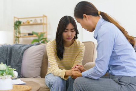 Female psychologist touching hands to comforting and encourage stress patient suffering depression.の素材