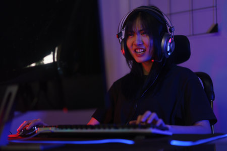 Female cyber hacker gamer in headphone serious face to playing games or hacking programming system.の写真素材