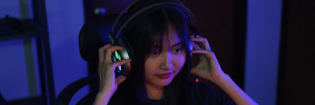 Female cyber hacker gamer in headphone watching video game on monitor to hacking programming system.の写真素材