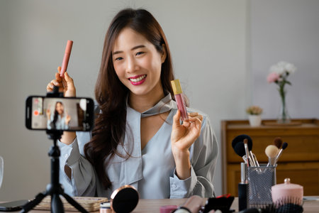 Beauty blogger holding lipstick and showing product to reviewing cosmetic in makeup vlogger.の写真素材