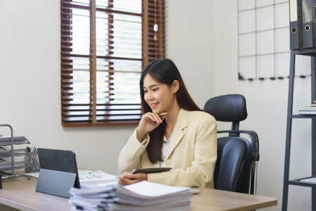 Secretary concept, Female secretary thoughtful while reading business data on tablet in office.の素材