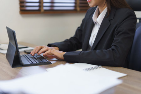 Secretary concept, Female secretary is working and typing report of business on tablet in office.の素材