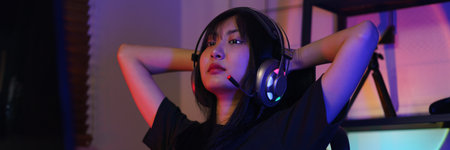 Female cyber hacker gamer holds hands behind head to resting after watching and hacking video games.の写真素材