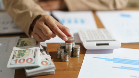 Businesswoman putting a coin on the pile of coins with saving money idea for investment business.の写真素材
