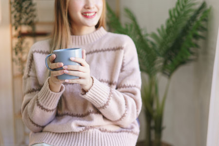Rest time concept, Women working on laptop while relaxing with drinking coffee and looking outside.