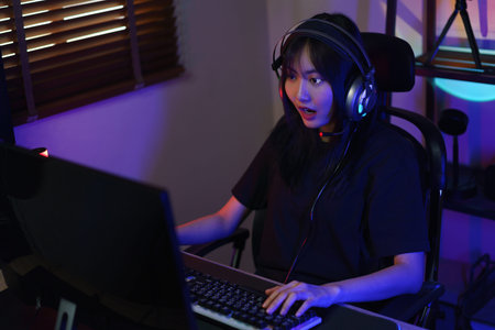 Female gamer in headphone excited while playing games or hacking programming system.