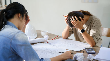 Concept of engineering consulting, Two engineers stressful while sketching blueprint of new project.の写真素材