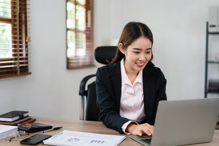 Businesswoman planning for marketing plan of new startup project and typing finance data on laptop.