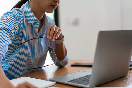 Close up of businesswoman is working on laptop and thinking about planning of new business project.