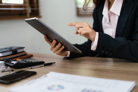 Businesswoman reading finance data on tablet to planning for marketing plan of new startup project.の写真素材