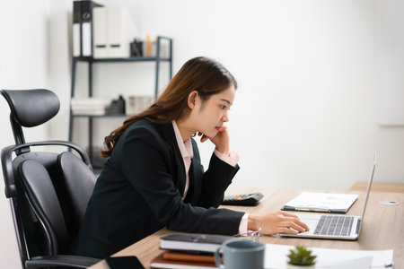 Businesswoman reading finance data on laptop to thinking for marketing plan of new startup project.の写真素材