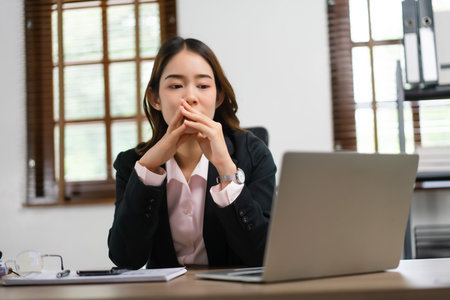 Businesswoman reading finance data on laptop to planning for marketing plan of new startup project.の写真素材