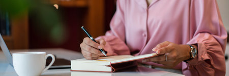 Female entrepreneur write data in notebook while working about strategy new startup in home office.の写真素材