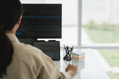 Developer programmer checking code on multiple monitor while programming to developing web and apps.の写真素材