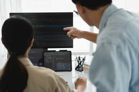 Two developer programmer checking code on multiple monitor while programming to developing website.の写真素材