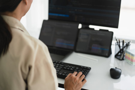 Developer programmer working about programming code to developing web and apps on multiple monitor.の写真素材