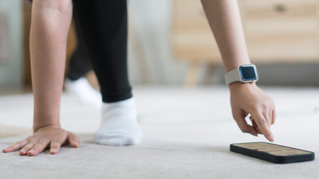Young asian woman checking workout time on smartphone while doing exercise with healthy lifestyle.