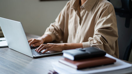 Female entrepreneur working with technology on laptop to typing financial data of startup project.