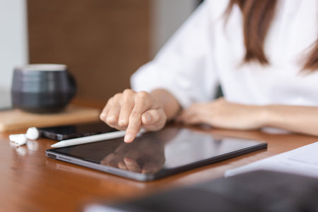 Businesswomen researching data and reading finance data on tablet while analysis about new startup.
