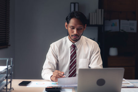 Businessman reading and checking business report to analysis financial and accounting of project.の写真素材