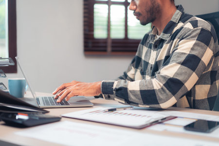 Businessman typing data on laptop while working to analysis financial and accounting of business.の写真素材