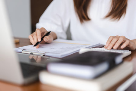 Businesswomen using calculator to checking financial document while working in outside office.