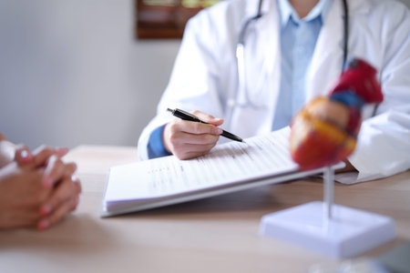 Asian cardiologist doctor women pointing on document to explaining about health examination results...