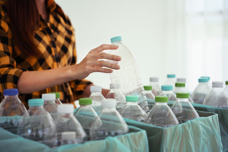 Women putting plastic bottle in cardboard box to reuse and recycling for sustainable environment.の写真素材