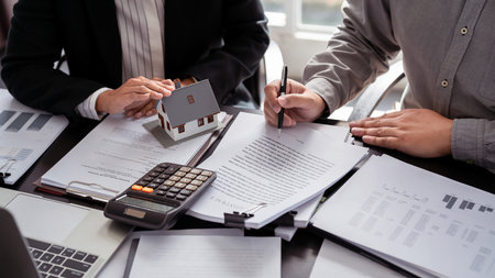 Businessman real estate seller explaining about property investment document with terms data of home...